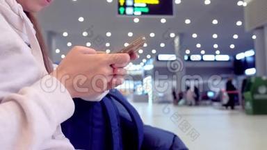 女士在机场大厅手机上在线登记，手拿智能手机特写..